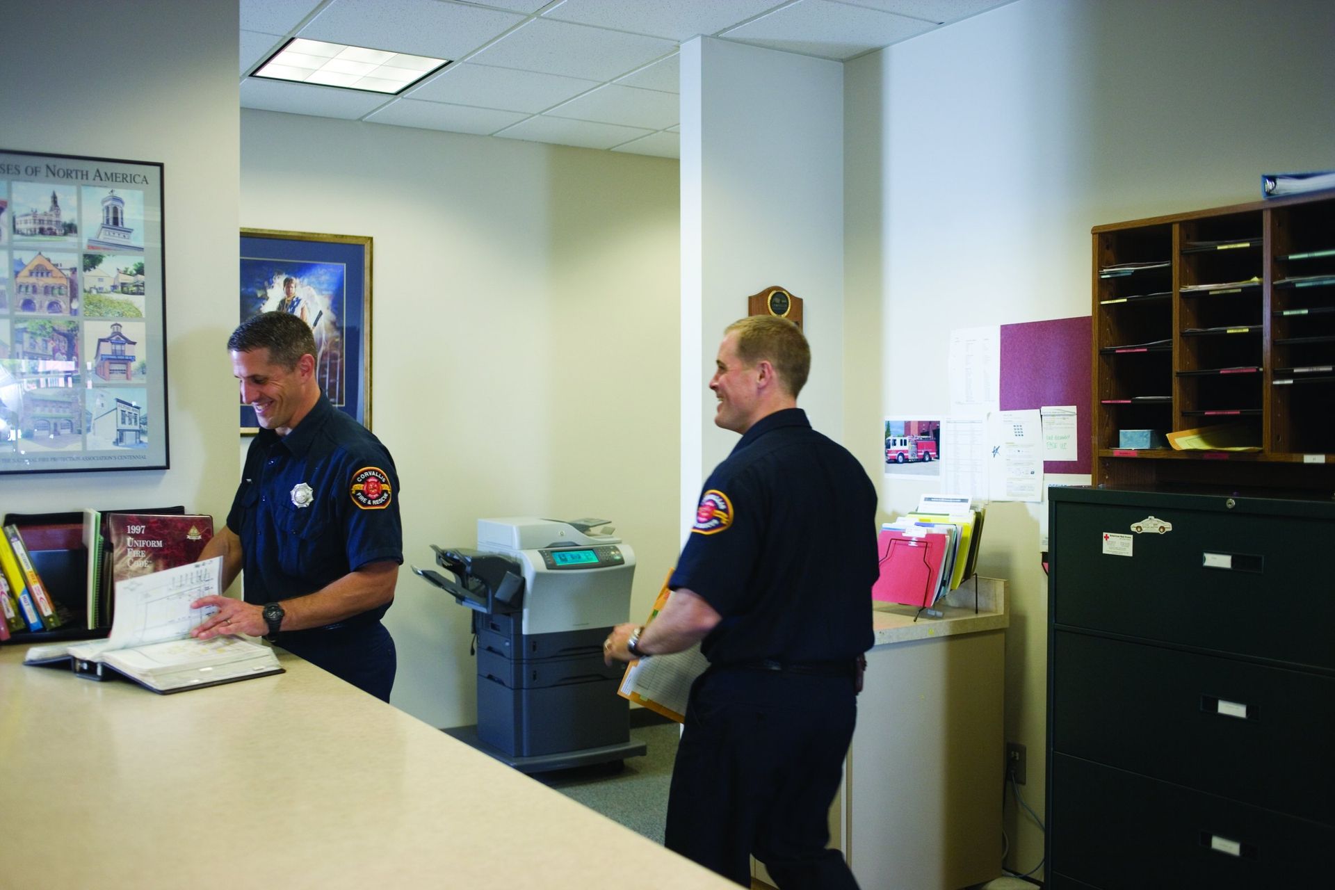 Firefighters in an office next to an HP multifunction printer